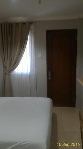 明古鲁省Omnea Hotel - Syariah的一间卧室设有床、窗户和门