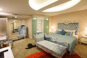 吉隆坡Maison Boutique Theme Hotel Kuala Lumpur by Swing & Pillows的一间卧室配有一张床、一把椅子和镜子