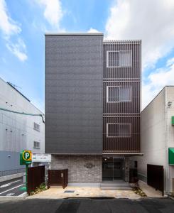 冈山GRAND BASE Okayama Ekimae的街道上一座高大的建筑,外墙黑色
