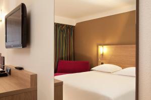 坎佩尔坎佩尔中心大洋洲艾思格尔酒店的酒店客房,配有一张床和一张红色椅子