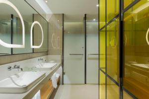 天津天津融侨套房假日酒店的一间带两个盥洗盆和淋浴的浴室