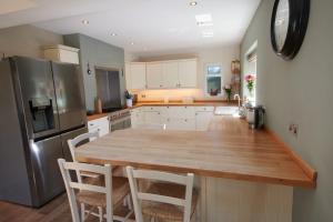 利明顿No.3 Buckland Cottages的厨房配有木桌和冰箱。
