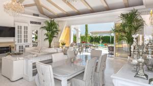 阳光海滩伊甸公园豪华别墅的用餐室以及带桌椅的起居室。