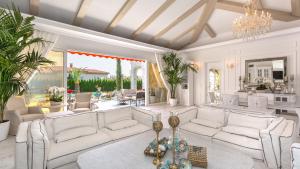 阳光海滩伊甸公园豪华别墅的客厅配有白色家具和吊灯。