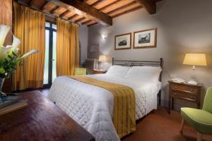 菲利内瓦尔达诺卡萨格兰德别墅及Spa度假酒店的卧室配有白色的床和绿色椅子