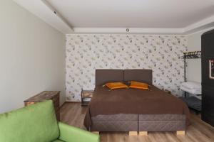 哈普萨卢Lapmanni Holiday Home的一间卧室配有一张床和一张绿色沙发
