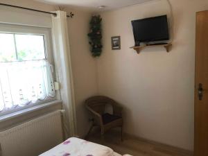 萨加尔德Fewo in sonniger Lage in Sagard的客房设有电视、椅子和窗户。