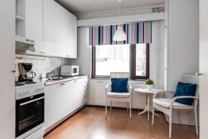肯佩莱Hotel Pohjankievari的厨房配有白色橱柜和桌椅
