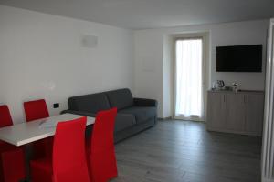 拉韦诺appartamenti i fiori del lago的客厅配有沙发、桌子和红色椅子