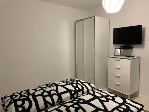 布克福尔多Zenit Apartman的一间卧室配有一张床和一个带电视的梳妆台