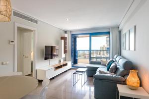 瓦伦西亚ApartUP Patacona Essence的客厅配有蓝色的沙发和电视