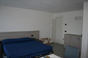 拉韦诺appartamenti i fiori del lago的一间卧室配有一张床、一张桌子和一把椅子