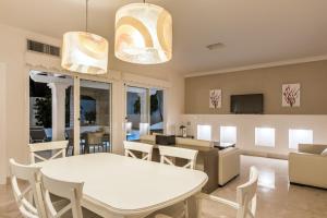 科拉雷侯Bahiazul Villas Corralejo by Vreagestion的用餐室以及带白色桌椅的起居室。