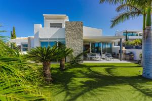 阿德耶Villa Eleonora, Luxury Villa with Heated Pool Ocean View in Adeje, Tenerife的一座大型白色房子,前面有棕榈树