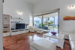 阿德耶Villa Eleonora, Luxury Villa with Heated Pool Ocean View in Adeje, Tenerife的客厅配有白色家具和平面电视