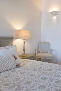纳乌萨Saint Andrea Seaside Resort的一间卧室配有一张带灯和椅子的床