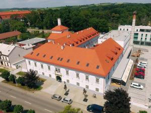HolešovHotel Panský Pivovar的享有白色大建筑的顶部景色,设有橙色屋顶