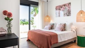 马贝拉Luxe Apartments Hotel del Golf - Las Brisas Marbella的卧室配有一张带粉红色枕头的大床