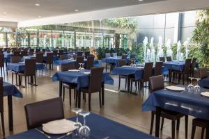 普拉加德阿罗RVHotels Nautic Park的一间配备有蓝色桌椅的用餐室