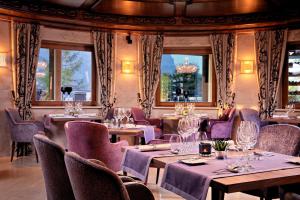 埃尔毛凯瑟霍夫高级酒店的餐厅设有桌椅和窗户。