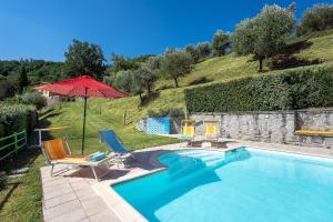 皮斯托亚Villa Mario, piscina privata,aria cond,immersa nel verde,campagna Toscana的一个带椅子和遮阳伞的游泳池