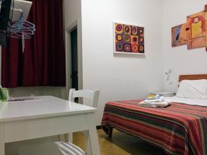 巴勒莫YooRoom的白色的客房配有床、桌子、桌子和桌子。
