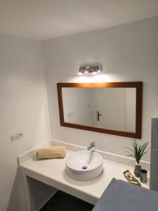 塔那那利佛曼德罗索庄园旅馆的浴室设有白色水槽和镜子
