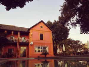 塔那那利佛曼德罗索庄园旅馆的一座橙色的房子,在水池中反射