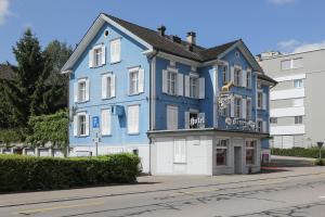 Niederuzwilhotel löwen的街道边的蓝色建筑