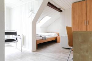 Niederuzwilhotel löwen的一间小卧室,配有一张床和一张书桌