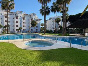 卡拉德米哈斯Mi Capricho Apartment with Sea Views and Gardens的棕榈树公园和建筑中的游泳池