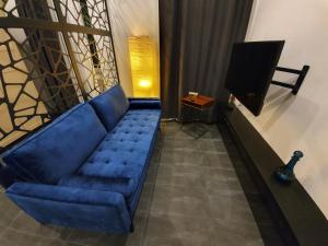 维也纳Design Apartment Favoritenstraße 147的客厅设有蓝色沙发,配有电视