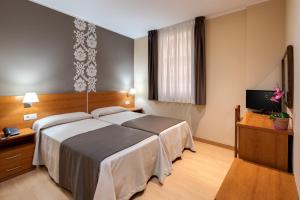 巴塞罗那加泰罗尼亚酒店的配有一张床和一台平面电视的酒店客房
