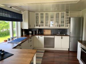 芬斯内斯House in central Finnsnes的厨房配有白色橱柜和不锈钢冰箱