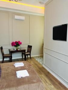 切尔诺夫策Апартаменти Кобилянська 9的客厅配有桌子和平面电视。