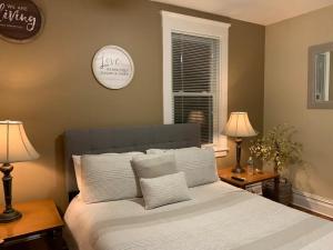 新罗谢尔Historical Neighborhood Home的一间卧室配有一张带两盏灯和闹钟的床。