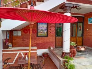 加德满都Chef House Resort的房子门廊上的红伞