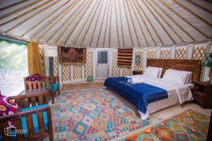 Roomy Yurts, Minapin Nagar Hunza的帐篷内一间卧室,配有一张床