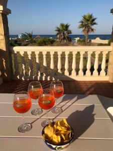 库列拉Beach House Villa Roca的三杯酒和一碗薯条放在桌上