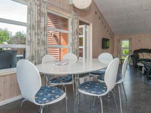 罗莫柯克比Holiday home Rømø XXVIII的一间配备有白色桌椅的用餐室