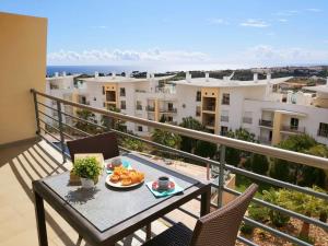 阿尔布费拉Sunny Apartment with sea view in Albufeira的阳台上的餐桌上放着一盘食物