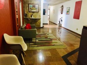 奥萨斯库Hotel Cambará - By UP Hotel的客厅配有椅子和地毯。
