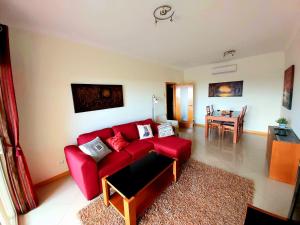 阿尔布费拉Sunny Apartment with sea view in Albufeira的客厅配有红色的沙发和桌子