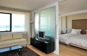 菲盖拉-达福什甜蜜大西洋酒店暨Spa的一间卧室配有一张床、一台电视和一张沙发