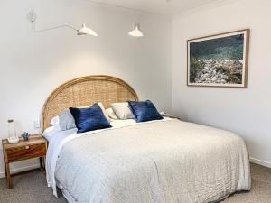 埃尔利海滩Pavilions Collection的一间卧室配有一张带蓝色枕头的大床