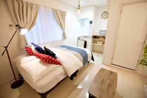东京R-Guest Residence 東京浅草 east2的一间卧室配有一张带枕头和桌子的床