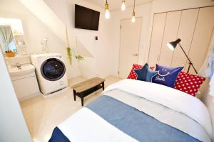 东京R-Guest Residence 東京浅草 east2的一间卧室配有一张床和一台洗衣机