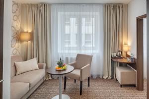 贝内绍夫阿特拉斯酒店的客厅配有沙发和窗户前的桌子