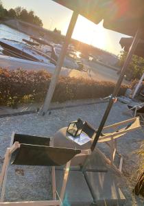 米科瓦伊基Avanti Resort Mikołajki , w centrum przy jeziorze i promenadzie, śniadanie i obiad lub obiadokolacja w cenie的海滩上的一把椅子和一把遮阳伞