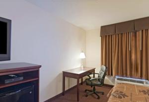 圣罗伯Americas Best Value Inn Saint Robert/Fort Leonard Wood的酒店客房配有书桌、床和电视。